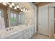 Bright bathroom featuring dual sinks, vanity, custom cabinets and modern lighting at 13025 Water Point Blvd, Windermere, FL 34786