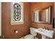 Elegant powder room with copper fixtures, decorative mirror and window at 13025 Water Point Blvd, Windermere, FL 34786