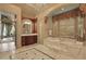 Elegant bathroom featuring marble floors, soaking tub, custom wood cabinets and chandelier at 13025 Water Point Blvd, Windermere, FL 34786