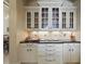 Beautiful butler's pantry with granite counters, tile backsplash, and custom glass front cabinets at 13025 Water Point Blvd, Windermere, FL 34786