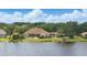 Stunning waterfront home featuring lush landscaping, a private dock, and a beautiful clay tile roof at 13025 Water Point Blvd, Windermere, FL 34786