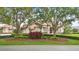 Elegant home exterior boasts lush landscaping, mature trees, and a beautiful tiled roof at 13025 Water Point Blvd, Windermere, FL 34786