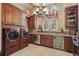 Laundry room with custom wooden cabinets, tile floor, and stainless steel appliances at 13025 Water Point Blvd, Windermere, FL 34786