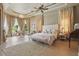 Spacious main bedroom with tray ceilings, chandelier, large windows and plush carpeting at 13025 Water Point Blvd, Windermere, FL 34786