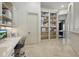 Bright home office with built-in shelving and drawers next to a hallway leading to the bedrooms at 13025 Water Point Blvd, Windermere, FL 34786
