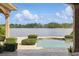 Gorgeous lake view from the pool area, framed by manicured hedges, showcasing a tranquil oasis at 13025 Water Point Blvd, Windermere, FL 34786