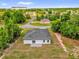 Aerial view of a white home with a gray roof, surrounded by trees and nearby houses at 13971 Sw 46Th Ter, Ocala, FL 34473