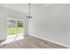 Minimalist dining area featuring light gray walls, wood flooring, and a glass sliding door to the outdoors at 13971 Sw 46Th Ter, Ocala, FL 34473