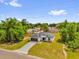 Single story home featuring a well-maintained lawn, gray roof, and a long driveway leading to the garage at 13971 Sw 46Th Ter, Ocala, FL 34473
