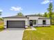 Inviting one-story home featuring a well-maintained lawn, a two-car garage, and modern exterior finishes at 13971 Sw 46Th Ter, Ocala, FL 34473