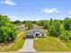 Beautiful single-story home with a gray roof, a long driveway, and lush green surroundings at 13971 Sw 46Th Ter, Ocala, FL 34473