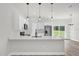 Open kitchen with an island, stainless steel appliances, white cabinetry, and sliding glass doors at 13971 Sw 46Th Ter, Ocala, FL 34473