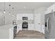 Bright kitchen featuring white cabinetry, stainless steel appliances, modern fixtures and wood grain flooring at 13971 Sw 46Th Ter, Ocala, FL 34473