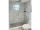 This bathroom features a tiled shower and flooring, rain shower head, and modern fixtures at 1414 Meadowlark St, Longwood, FL 32750
