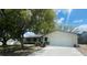 Charming single-story home with a well-manicured lawn, mature shade tree, and a blue front door at 1414 Meadowlark St, Longwood, FL 32750