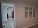 Hallway view leading to an open living area with light, wooden flooring and decorative art on the wall at 1414 Meadowlark St, Longwood, FL 32750