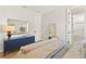 Bright bedroom features a large mirror, blue dresser, and ensuite bathroom for added convenience at 16018 Volterra Pt, Bella Collina, FL 34756
