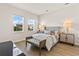 A bright bedroom features two windows, wood-look floors, and neutral decor at 16018 Volterra Pt, Bella Collina, FL 34756