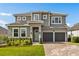 Two-story home featuring a two-car garage, brick driveway, well-manicured lawn and light-green front door at 16018 Volterra Pt, Bella Collina, FL 34756