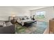 Bright main bedroom with modern rug, a cushioned bench, exercise bike, and view of a golf course at 16018 Volterra Pt, Bella Collina, FL 34756