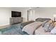 Bright main bedroom with modern rug, a cushioned bench, media cabinet and view of the en suite bathroom at 16018 Volterra Pt, Bella Collina, FL 34756