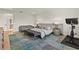 Bright main bedroom with modern rug, a cushioned bench, exercise bike, and view of a golf course at 16018 Volterra Pt, Bella Collina, FL 34756