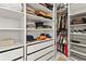 Organized walk-in closet featuring custom shelves, drawers, and hanging rods to neatly store clothes and accessories at 16018 Volterra Pt, Bella Collina, FL 34756