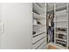 Organized walk-in closet featuring custom shelves, drawers, and hanging rods to neatly store clothes and accessories at 16018 Volterra Pt, Bella Collina, FL 34756