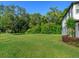 Large green lawn with trees, shrubs and a view of the home's exterior at 1628 Little Wren Ln, Winter Park, FL 32792