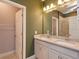 Bright bathroom featuring a double vanity with white cabinets and granite countertops at 1628 Little Wren Ln, Winter Park, FL 32792