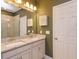Bathroom featuring a double vanity, large mirror, and modern light fixture at 1628 Little Wren Ln, Winter Park, FL 32792