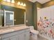 Bathroom with floral curtain, granite countertop, white cabinetry, and modern toilet at 1628 Little Wren Ln, Winter Park, FL 32792