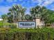 Welcoming entrance to The Enclave at Hawk's Crest with lush landscaping, scenic pond views, and a stately stone sign at 1628 Little Wren Ln, Winter Park, FL 32792