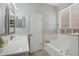 Bright bathroom features a soaking tub, vanity with sink, and neutral tile throughout at 16810 Sunrise Vista Dr, Clermont, FL 34714