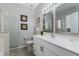 Bright bathroom featuring a white vanity, dual mirrors, and a glass-enclosed shower creating a fresh and clean space at 16810 Sunrise Vista Dr, Clermont, FL 34714