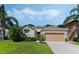 Charming single-story home featuring a well-manicured lawn, lush landscaping, and a welcoming facade at 16810 Sunrise Vista Dr, Clermont, FL 34714