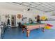 Spacious garage game room with pool table, foosball, exercise machine, and bar area at 16810 Sunrise Vista Dr, Clermont, FL 34714