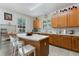 Bright kitchen featuring an island with seating, oak cabinets, and natural light from a garden window at 16810 Sunrise Vista Dr, Clermont, FL 34714