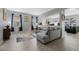 Bright living room featuring a gray sofa, natural light from the windows, and neutral tile flooring at 16810 Sunrise Vista Dr, Clermont, FL 34714