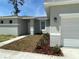 Inviting entryway with fresh landscaping leading to the front door and garage at 1734 Sail Ct, Kissimmee, FL 34759