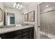 Elegant bathroom with a double sink vanity, granite countertop, and tiled shower at 2036 Lelani Cir, Davenport, FL 33897