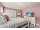 Inviting bedroom with a queen-sized bed, closet, dresser, and calming pink walls at 2036 Lelani Cir, Davenport, FL 33897