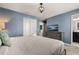 Comfortable bedroom with light blue walls, a queen bed, dresser with TV, and an ensuite bathroom at 2036 Lelani Cir, Davenport, FL 33897
