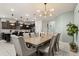 This stylish dining area showcases a modern chandelier, seating for eight, and seamless access to the kitchen at 2036 Lelani Cir, Davenport, FL 33897
