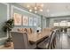 This elegant dining room features tufted chairs, neutral decor, modern lighting and access to a backyard retreat at 2036 Lelani Cir, Davenport, FL 33897