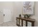 This welcoming entryway features modern console with mirrored cabinet doors, tiled floors and elegant floral wall decor at 2036 Lelani Cir, Davenport, FL 33897