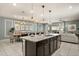 A modern, open-concept kitchen with a granite island, pendant lighting, and tile flooring offers both style and functionality at 2036 Lelani Cir, Davenport, FL 33897