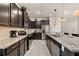 Modern kitchen with granite countertops, stainless steel appliances, dark cabinets, and tile backsplash at 2036 Lelani Cir, Davenport, FL 33897