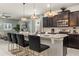 Modern kitchen with granite countertops, stainless steel appliances, dark cabinets, and stylish pendant lighting at 2036 Lelani Cir, Davenport, FL 33897