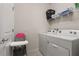 Functional laundry room with a washer, dryer, and convenient storage shelves at 2036 Lelani Cir, Davenport, FL 33897